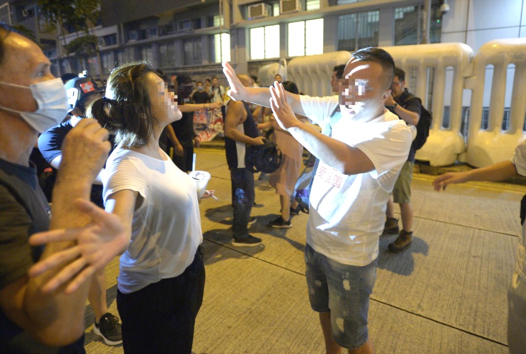 2名白色上衣的男子，與在場人群發生口角