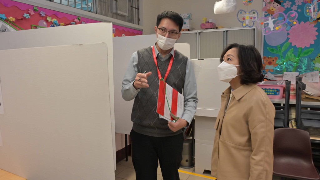 麥美娟（圖右）今巡視設於北區粉嶺公立學校的投票站，與工作人員交談，了解他們的工作。（政府新聞處圖片）