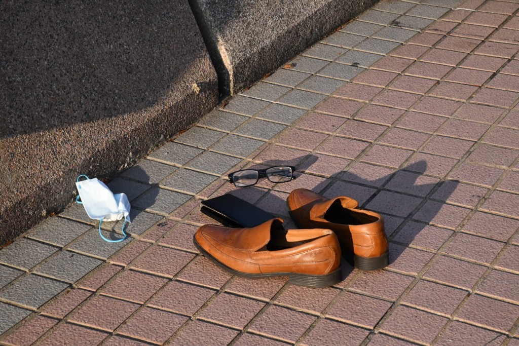 警方在岸边发现一对皮鞋、眼镜、手机及口罩，怀疑属于事主。