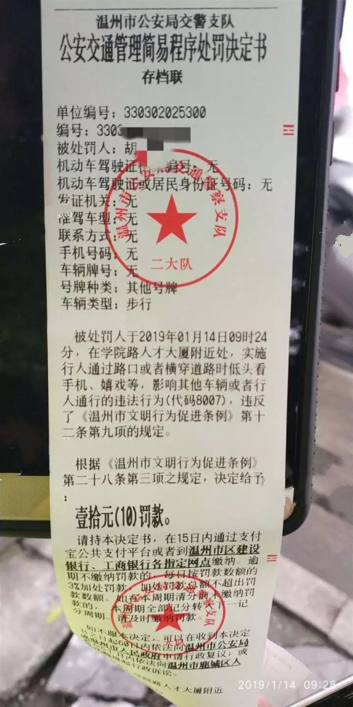 路人看手機被罰款成全國首宗。網上圖片