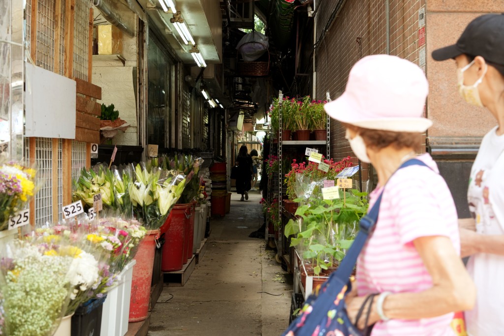 有花店后巷堆满纸皮、胶箱、盆栽等杂物，十分拥挤，只能一人走过。吴艳玲摄