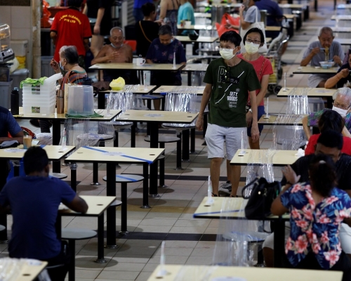 新加坡疫情持續，民眾用餐時都依循社交距離。REUTERS圖片