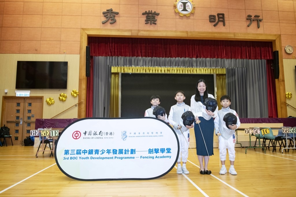 秀明小學校長曾嘉文（右二）與參與計劃的三年級學生冼樂研、余晉勳及劉智聰合照。學生一致認為劍擊訓練讓他們學會專心聆聽、細心觀察。