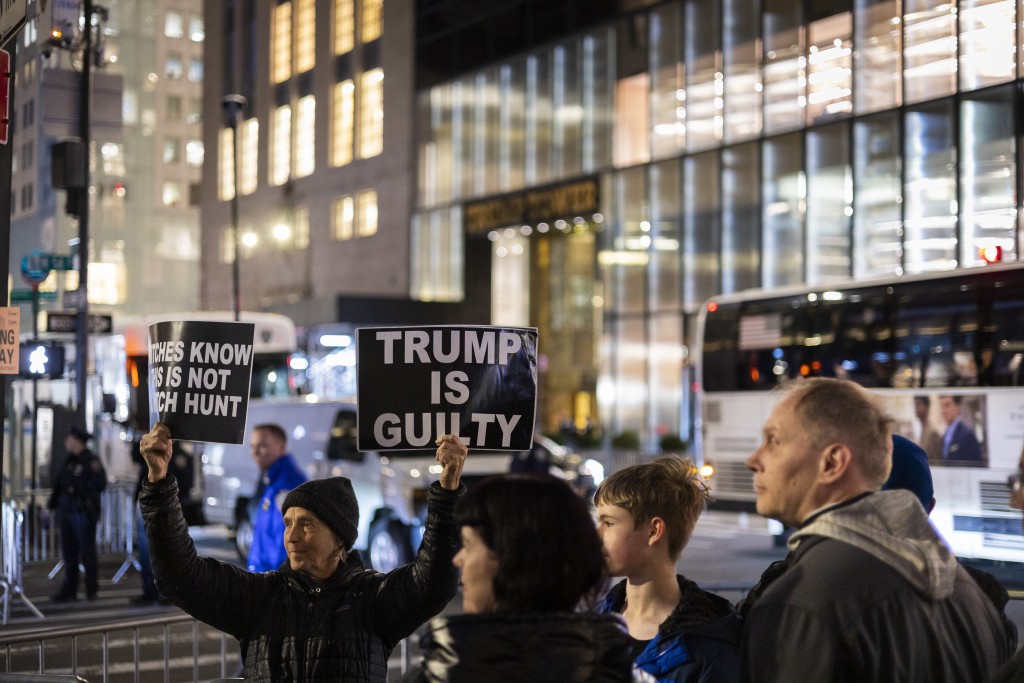 反對特朗普的示威者，舉起指他有罪的標語。AP
