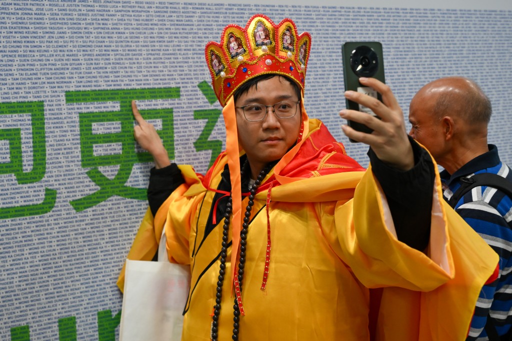 邓生今年选择身穿象征佛学的袈裟跑宣扬随遇而安的心态。摄影：魏国谦