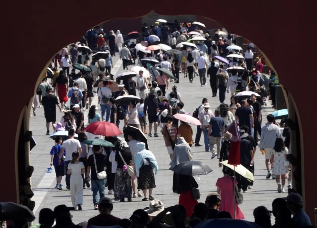 北京高溫，天壇不少遊客都要舉傘。