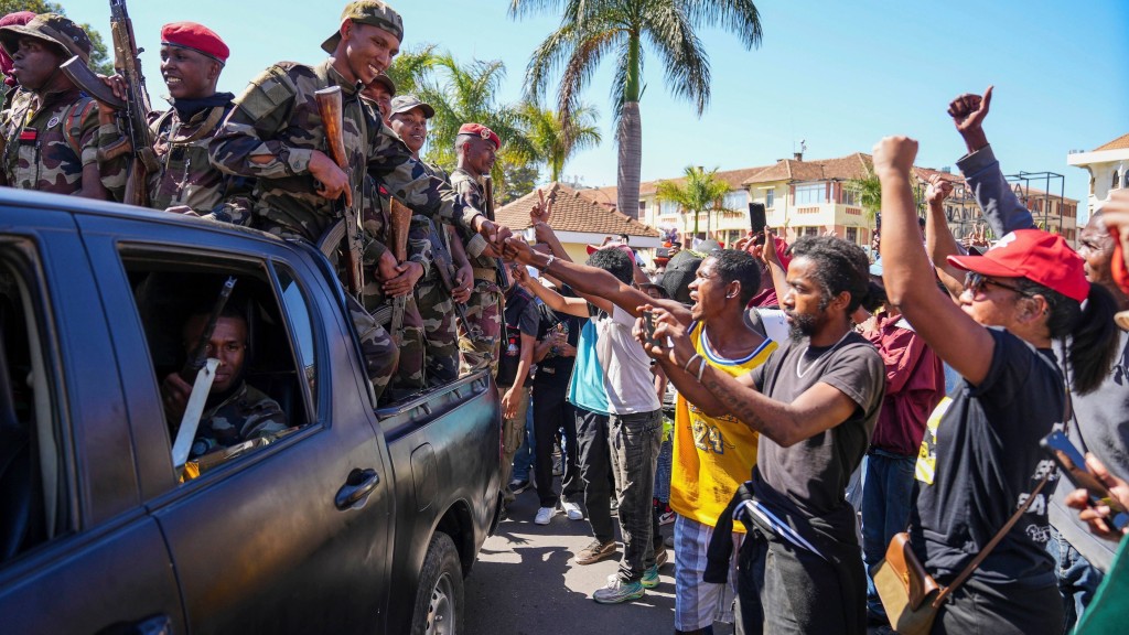 馬達加斯加民眾在島中心悼念反政府示威者的民眾向士兵致敬。美聯社 馬達加斯加民眾在島中心悼念反政府示威者的民眾向士兵致敬。美聯社