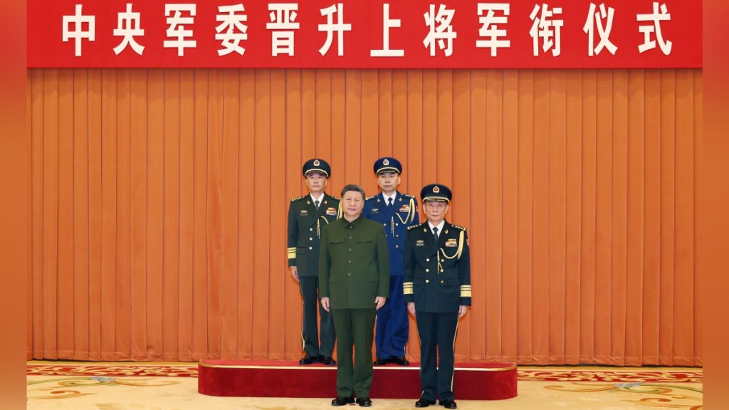中央军委主席习近平出席晋衔仪式，向晋升上将军衔的张曙光（后左）、王刚（后右）颁发命令状。新华社