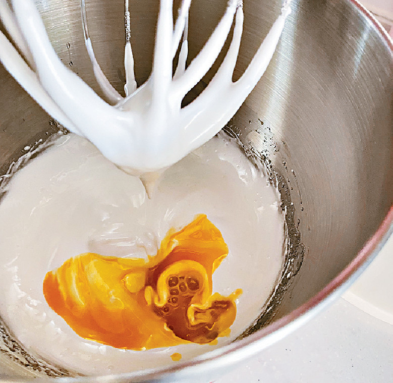 2.加入蛋黃繼續攪拌，再拌入牛奶和蜜糖。拌入麵粉拌勻後加菜油續拌成蛋漿。