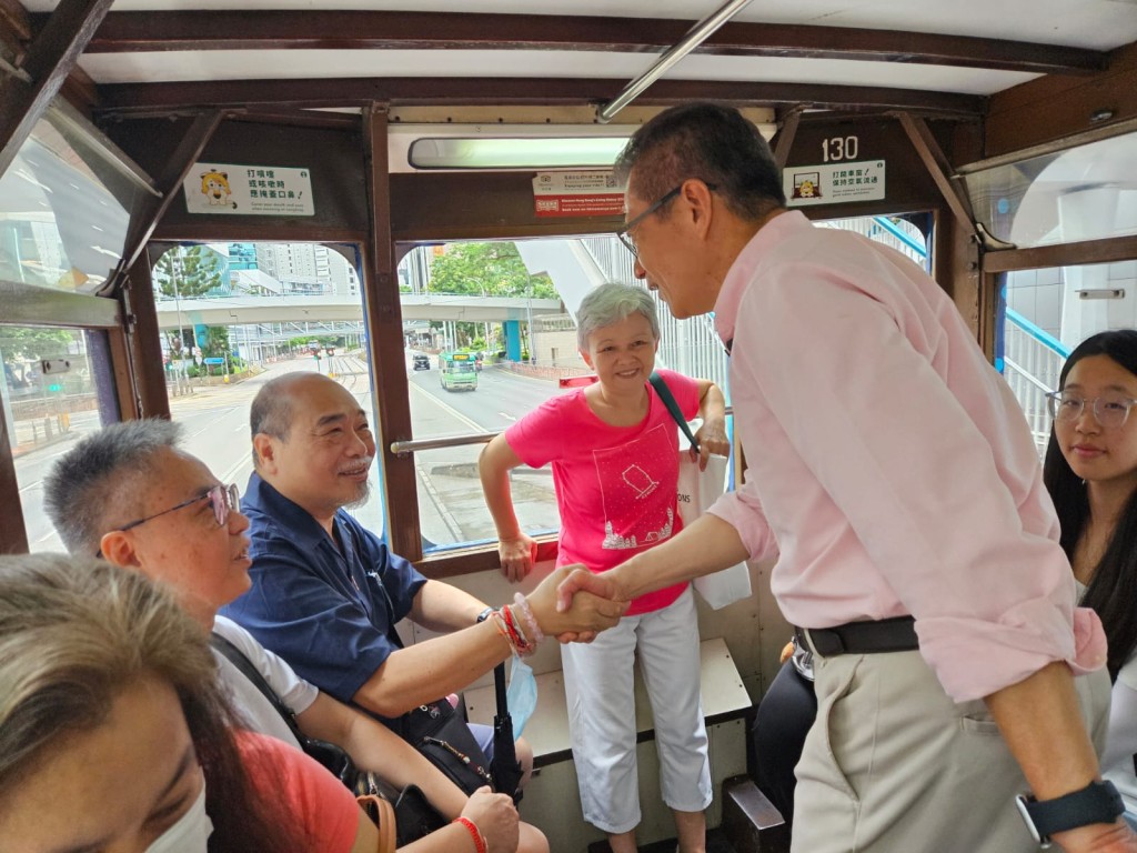 陳茂波與車上的市民握手和交談。