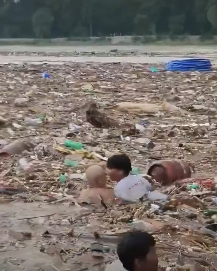 民眾冒險跳進漂浮垃圾堆中拖走石油氣瓶,以免發生爆炸。@jyotimagan555 / X 民眾冒險跳進漂浮垃圾堆中拖走石油氣瓶,以免發生爆炸。@jyotimagan555 / X