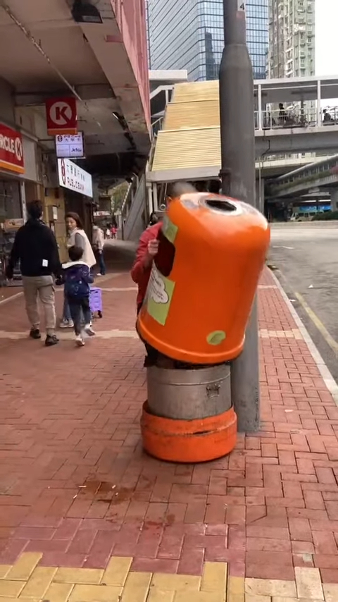 「光头Bob」打开街上的垃圾桶。