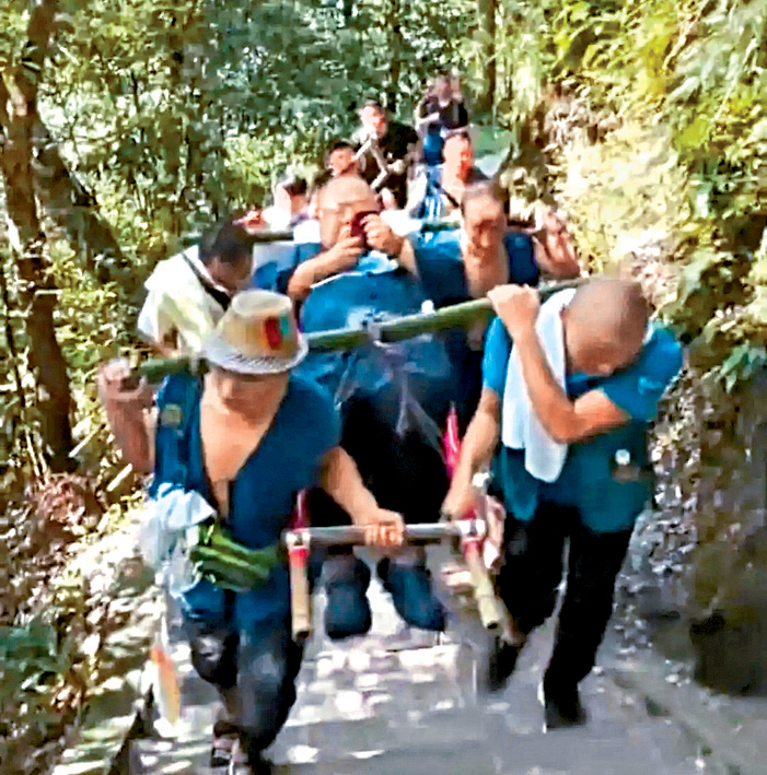 轎夫合力把男子抬上山。
