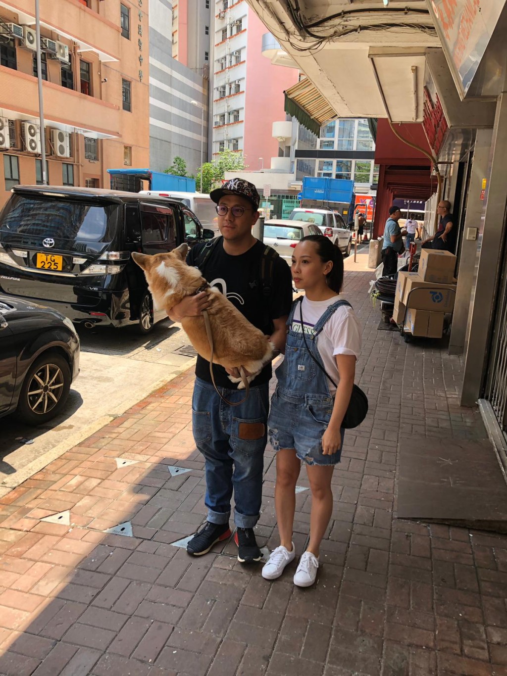 張致恒頭戴cap帽街坊裝、與太太一起帶愛犬睇醫生。