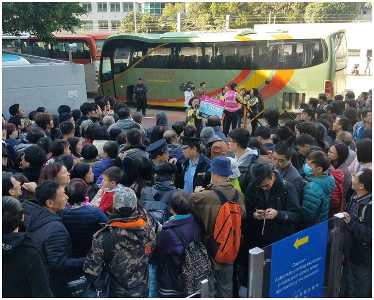 乘客打蛇餅等候接駁巴士。歐陽偉光攝