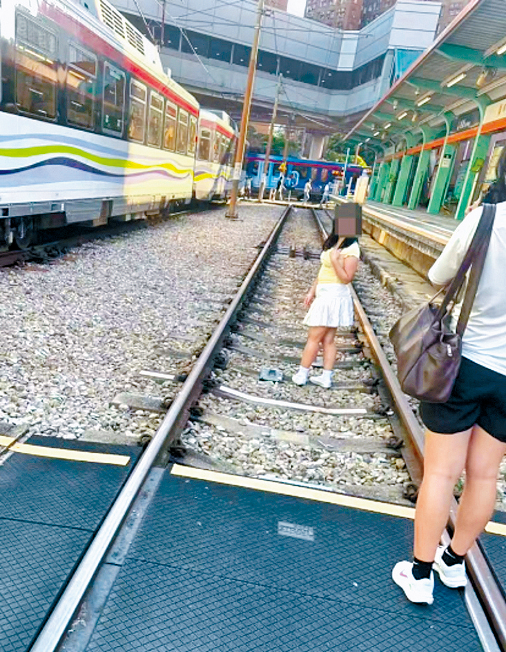 女子闖入輕鐵路軌拍照時，右側的月台剛巧有列車停靠。