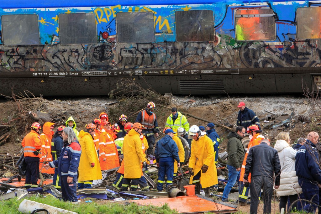 搜救人員在希臘火車相撞現場尋找失蹤者。