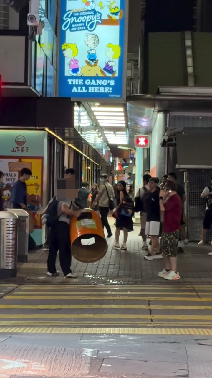 男子將路邊的垃圾桶蓋拿起,企圖拋向人群施襲。Threads@coc_.nut片段截圖 男子將路邊的垃圾桶蓋拿起,企圖拋向人群施襲。Threads@coc_.nut片段截圖