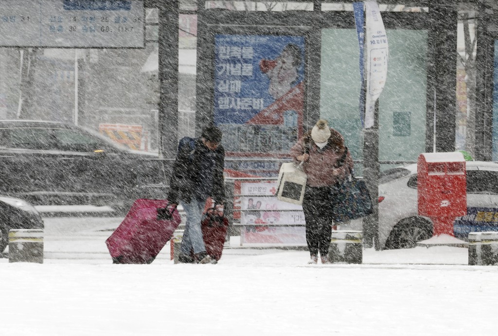 南韓光州大雪中市民在巴士站等車。美聯社