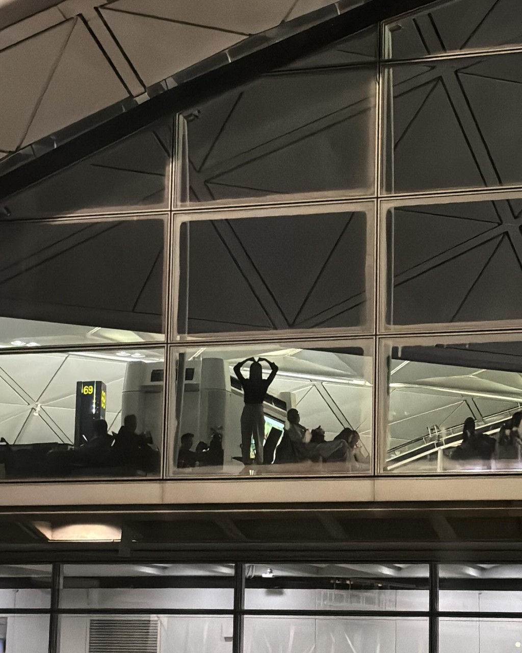 盛劲为更分享疑似是未婚妻麦明诗在机场落地窗前做出心型姿势的照片，大晒幸福。