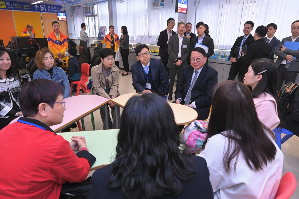 陳國基（坐下，左五）和孫玉菡（坐下，左四）與家長交流，了解他們重回職場的情況。政府新聞處圖片
