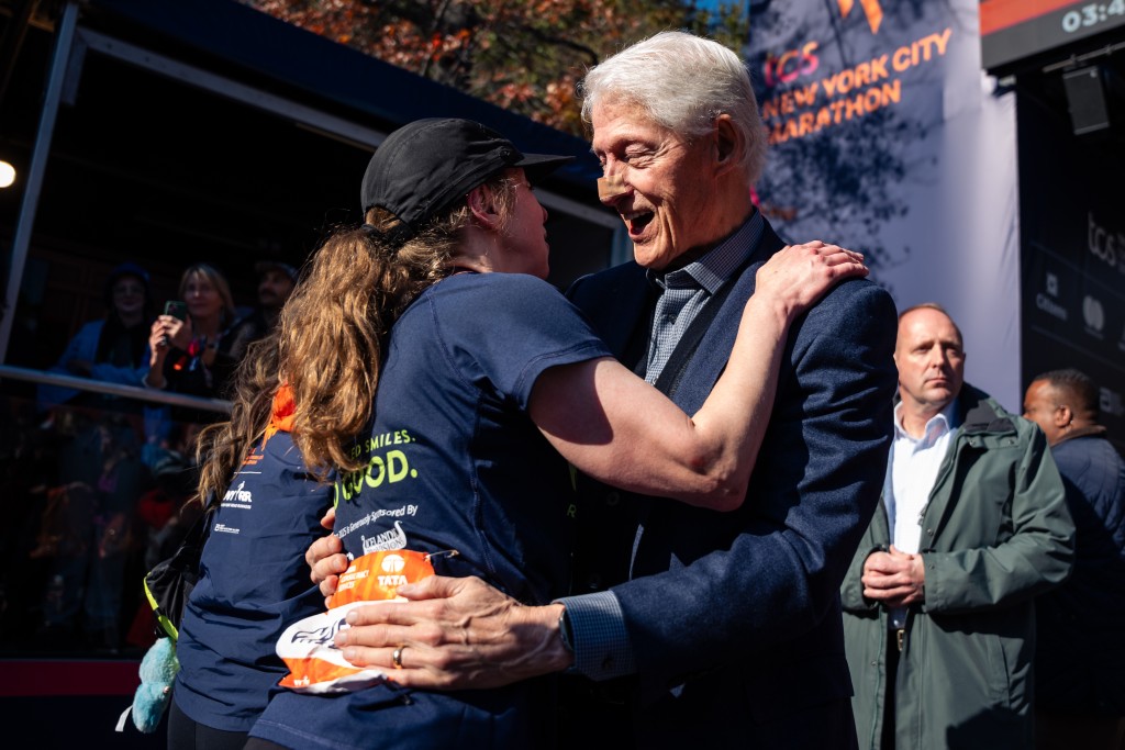 克林頓在紐約馬拉松終點線，與完賽的女兒切爾西（左）擁抱。他鼻頭上的膠布十分明顯，引發外界對其健康狀況的關注。美聯社