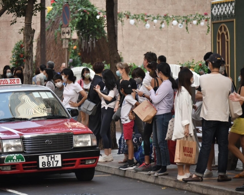市面人流增加,市民等上的士。