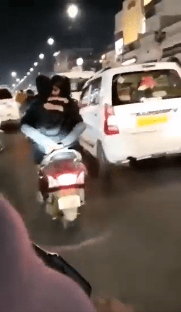 印度一对情侣竟边骑车边热吻。（截图自Twiiter）