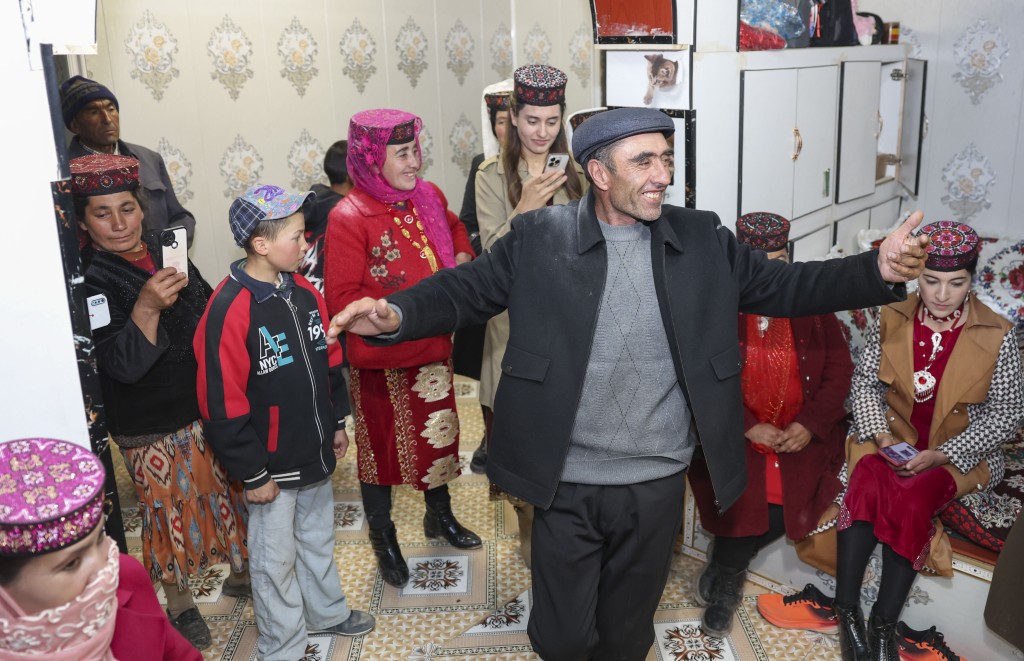 在位于新疆塔什库尔干塔吉克斯坦自治县瓦恰乡夏布孜喀拉村的家中，父亲多力开·百尔飞克跳起舞蹈庆祝女儿回家探亲。 新华社