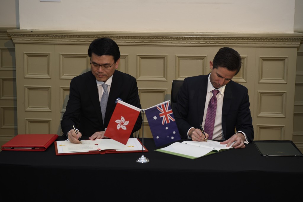 邱騰華(左)在澳洲悉尼與澳洲貿易、旅遊和投資部長伯明翰簽署香港與澳洲《自由貿易協定》和《投資協定》。 政府圖片