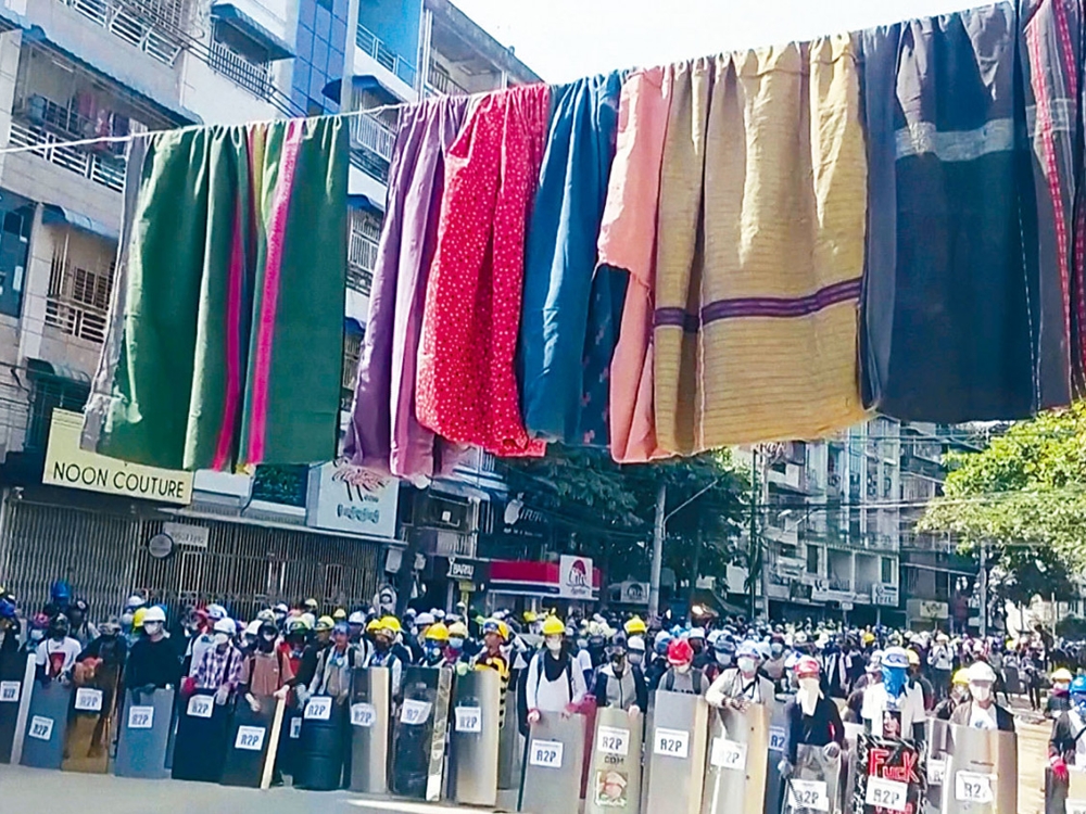 在仰光一個示威地點，昨日可見持盾牌的示威者前面，掛起傳統女性筒裙。網圖