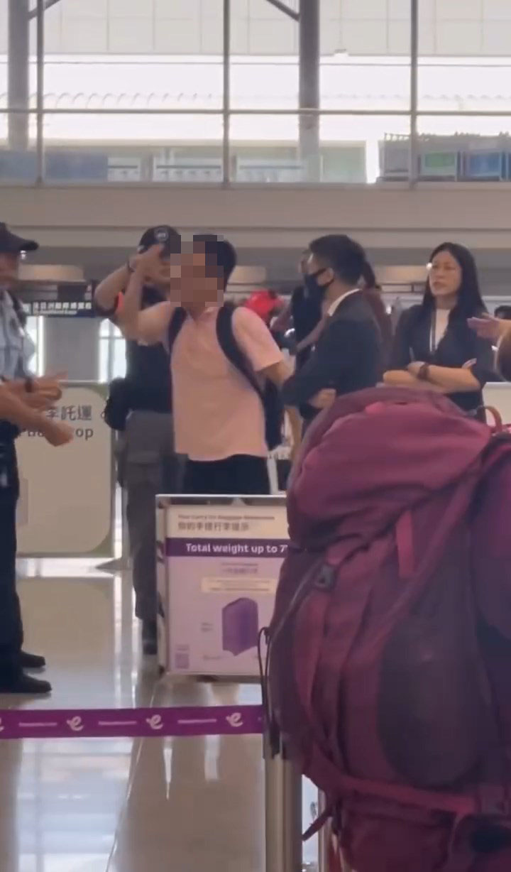 男子情緒激動，走近一名穿西裝的地勤男職員指：「佢話唔得！」。網上片段截圖