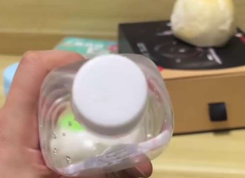 男子察觉蒸馏水的盖有异，疑有针孔，挤压空樽时有空气喷出。