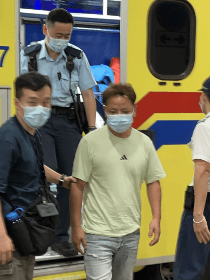 被捕男子戴上口罩,獲警員解除雙手手銬,自行步下救護車,接受治理。蔡楚輝攝 被捕男子戴上口罩,獲警員解除雙手手銬,自行步下救護車,接受治理。蔡楚輝攝