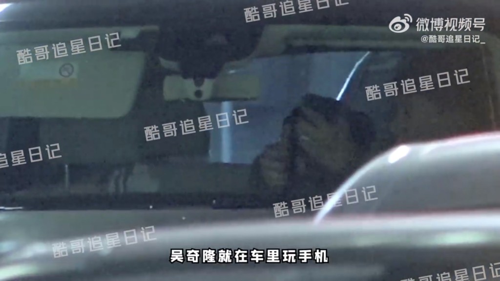 上车后吴奇隆在玩电话。（酷哥追星日记微博图片）