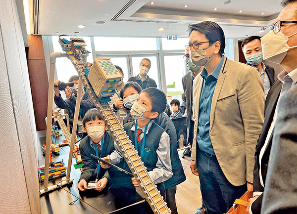 邓家彪在立法会观赏一班小学生自己设计及制作的缆车系统模型。