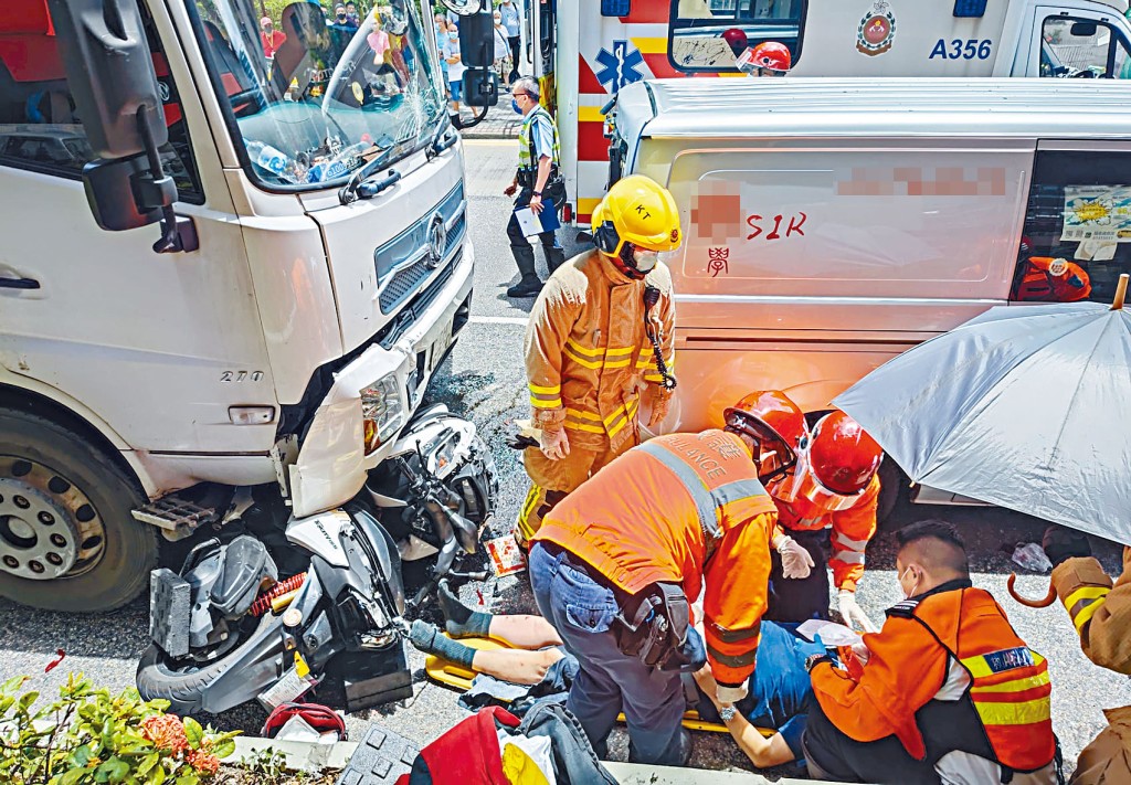 電單車成廢鐵,女乘客不治。救護員替姓李「鐵騎士」戴上頸箍。