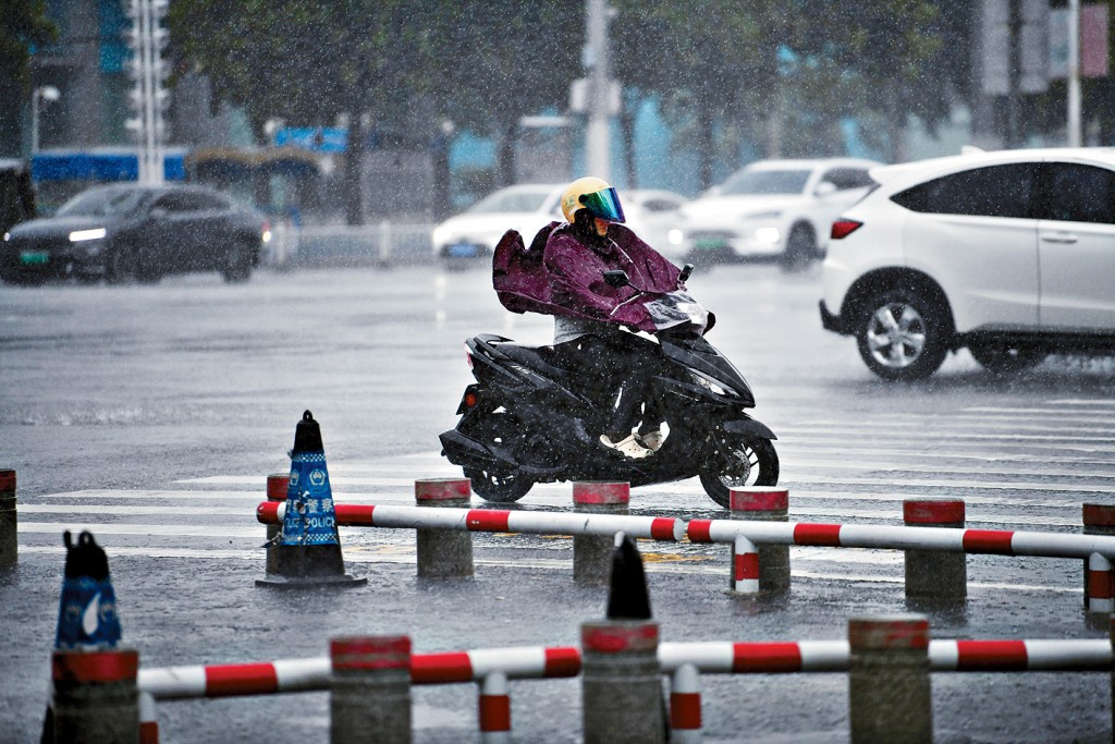 颱風「蝴蝶」過境,廣西北海市民冒雨出行。