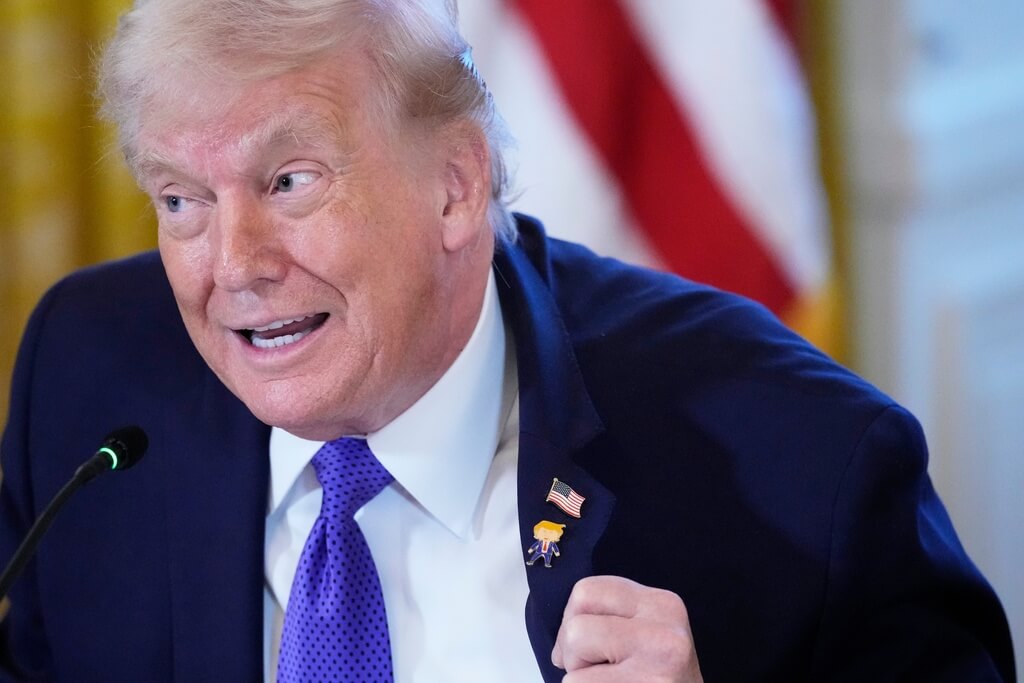 特朗普在西裝翻領上別「快樂特朗普」卡通別針。美聯社 特朗普在西裝翻領上別「快樂特朗普」卡通別針。美聯社