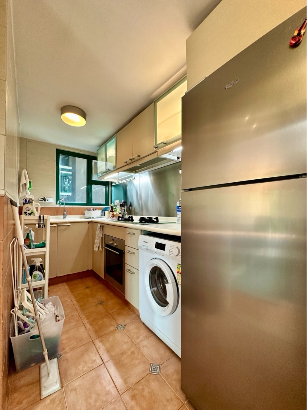 長形廚房以暖色系設計，附有上下列廚櫃。