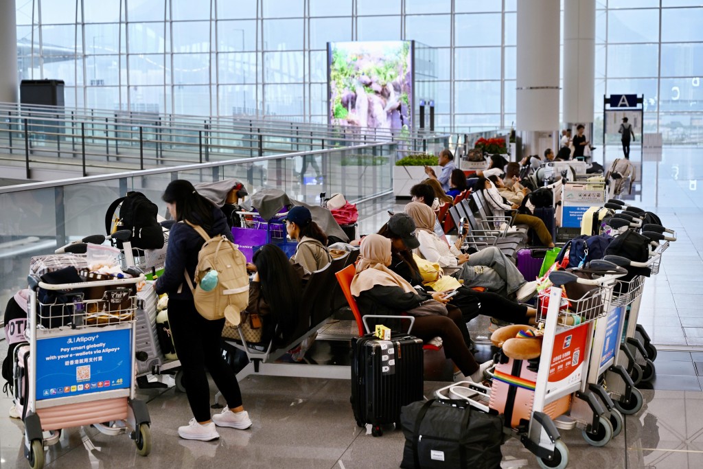 紅霞吹襲香港令數以百計航班取消,不少旅客滯留機場。 紅霞吹襲香港令數以百計航班取消,不少旅客滯留機場。