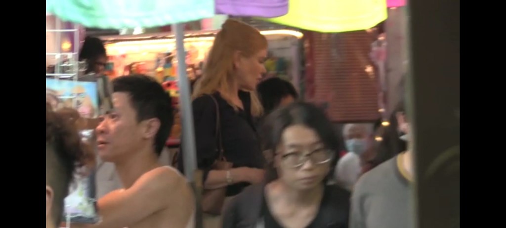 妮歌喺檔口前細看。