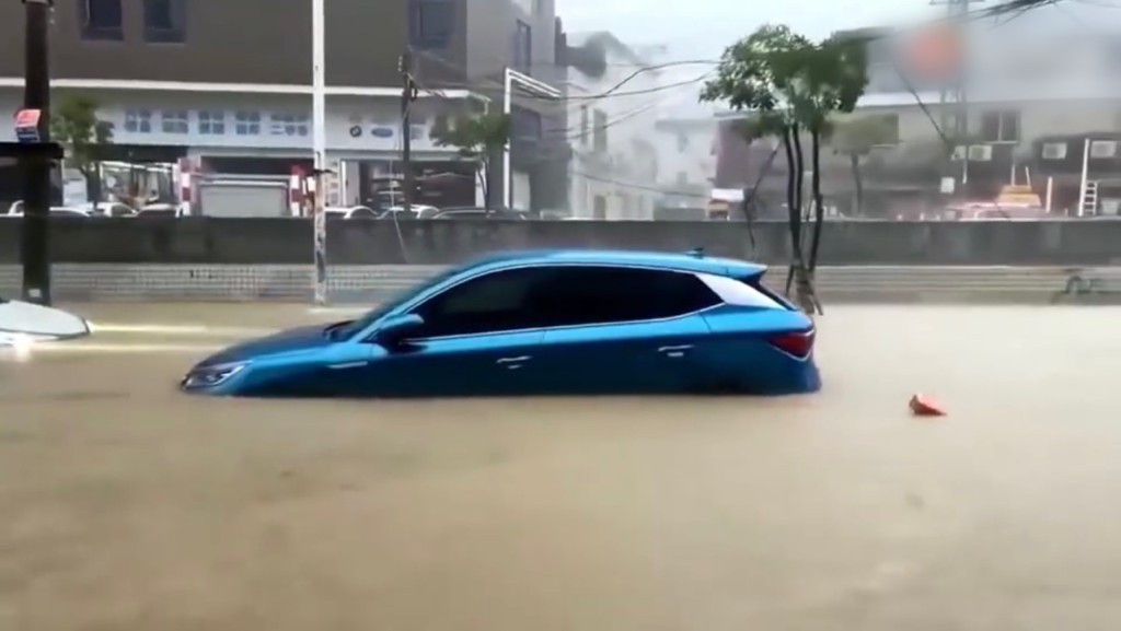 长安一处水浸，一辆蓝色汽车沿路被冲走。