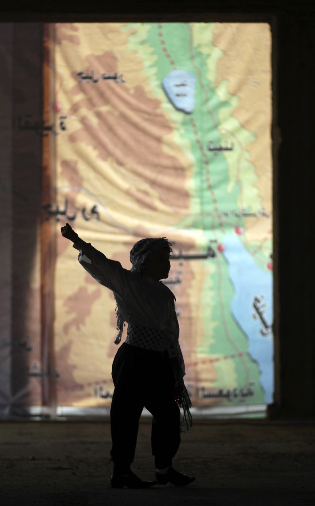 一名巴勒斯坦男孩在加沙城一張顯示英屬託管地巴勒斯坦部分地區的地圖前跳舞。 路透社