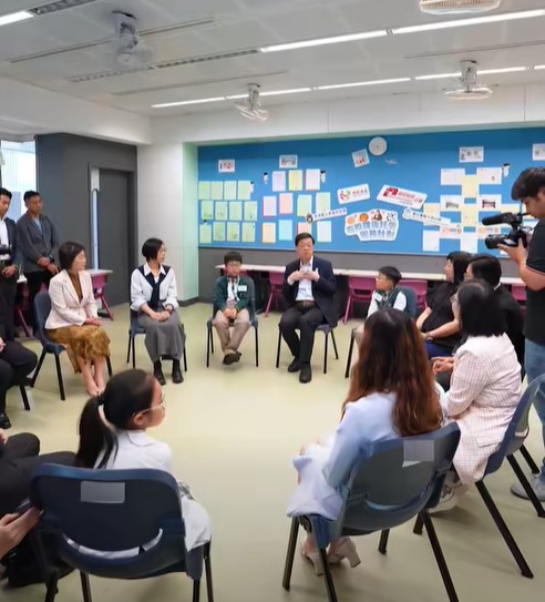 李家超與數名前來準備接放學的家長及其子女交流,了解他們對計劃的看法。 李家超與數名前來準備接放學的家長及其子女交流,了解他們對計劃的看法。
