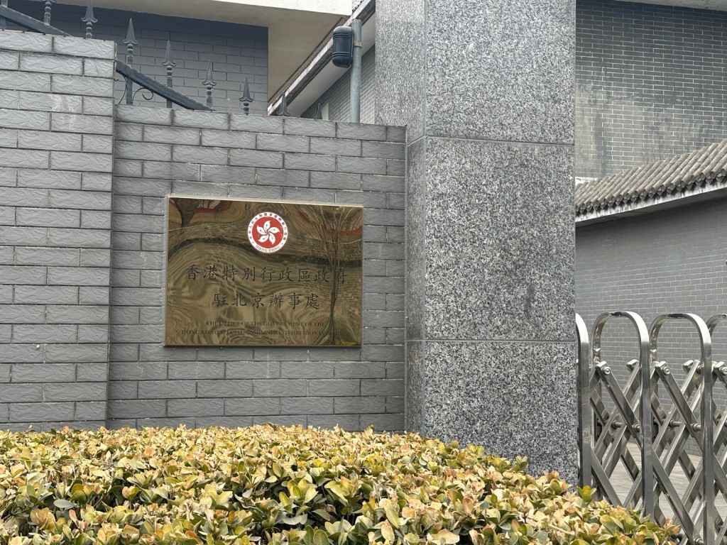 特區政府駐北京辦事處門外保安嚴密，李家超一行人乘車進入駐京辦後，保安人員隨即拉起鐵閘。何嘉敏攝