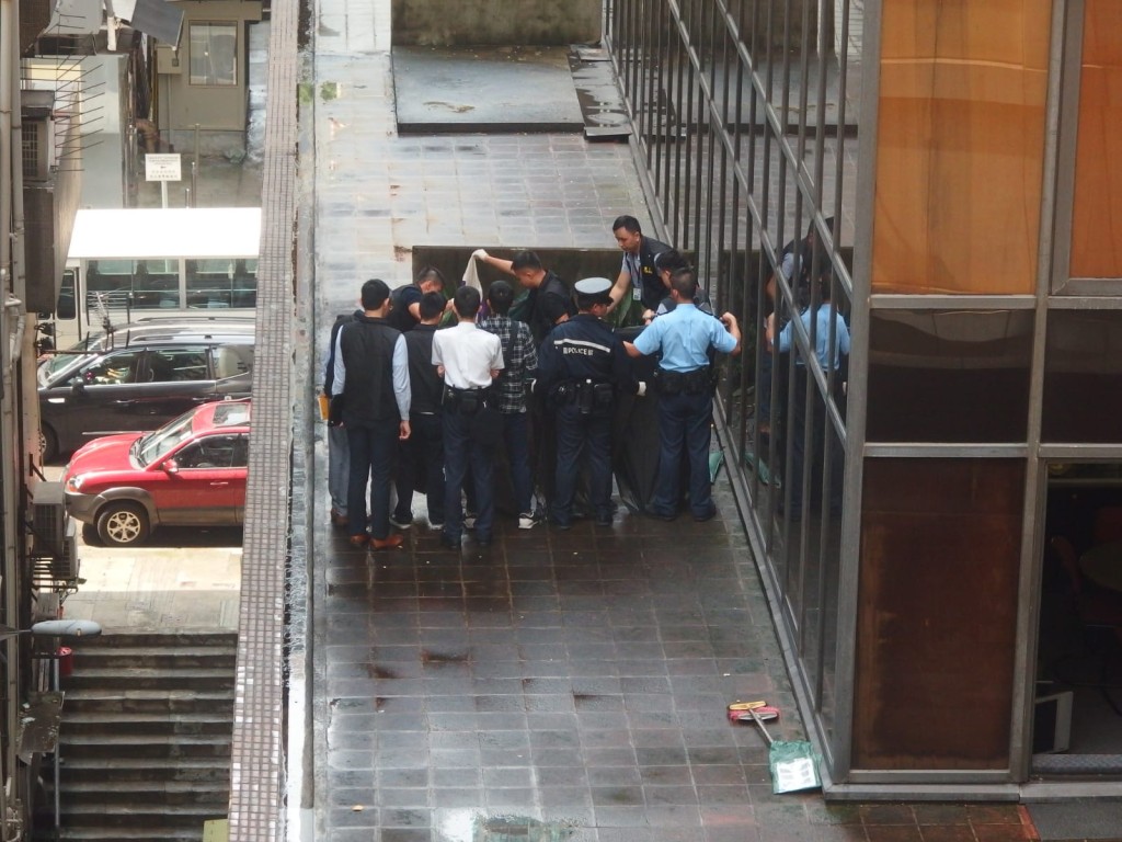 男死者於皇后大道中340號華秦國際大廈墮下,倒臥大廈平台。楊偉亨攝