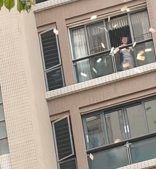 婦人將大批1,000港元的「金牛」撒落街。fb「港車北上分享群」影片截圖