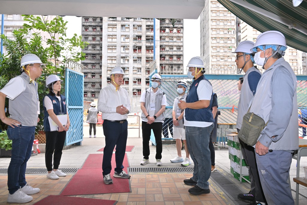 卓永興（左三）在大埔浸信會公立學校，向地區服務及關愛隊伍隊員支援上樓居民，表達謝意。