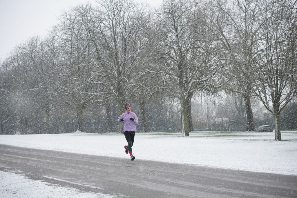 一名慢跑者清晨在伯克郡溫莎城堡的滿是積雪的長途步道裡跑步。AP